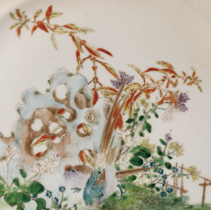 圖為1909年廣彩“廣東博物商會(huì)”石景紋碟細(xì)節(jié)圖，此碟將傳統(tǒng)國(guó)畫藝術(shù)與廣彩瓷技藝結(jié)合在一起，來(lái)表現(xiàn)優(yōu)美的石景風(fēng)光，畫面清新簡(jiǎn)潔。廣東博物商會(huì)由高劍父、陳樹人等人于1908 年在廣州市珠江南保安社八號(hào)以股份形式創(chuàng)辦，高劍父擔(dān)任會(huì)長(zhǎng)。畫師們以墨彩、綠彩、黃彩、大紅為主，運(yùn)用嶺南畫派繪畫技法，區(qū)別于傳統(tǒng)廣州彩瓷。（來(lái)源：廣州十三行博物館）