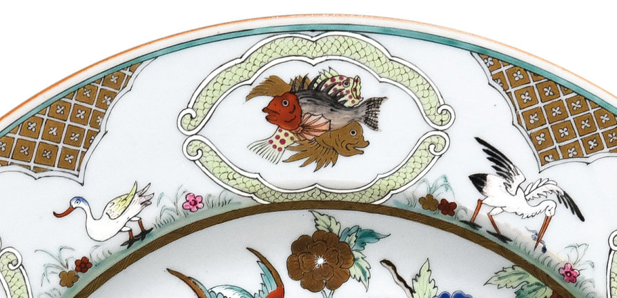圖為清中期廣彩人物紋大碟細(xì)節(jié)圖，碟沿對稱開六窗繪魚紋，間繪六組鳥禽紋。（來源：廣州十三行博物館）