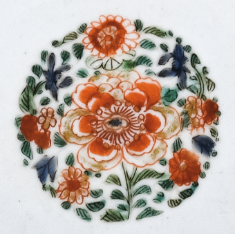 圖為清代五彩花卉紋碟細(xì)節(jié)圖，碟心主題紋飾為團(tuán)花圖，紅花綠葉，相映成趣。（來源：廣州十三行博物館）